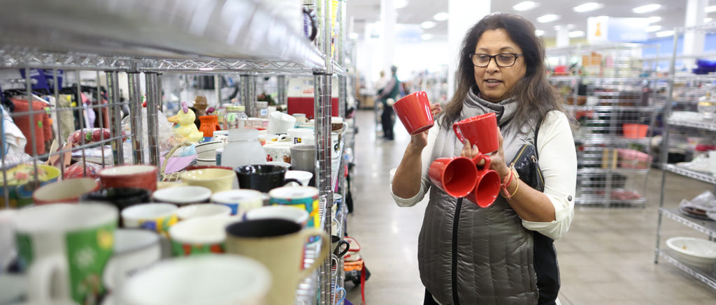 image of women in Goodwill store holding coffee mugs