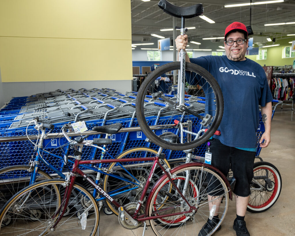 Goodwill South Central Wisconsin staff holding a unicycle